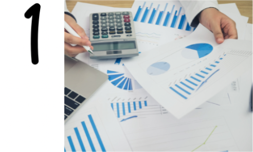 A person holds a paper with blue charts and graphs, surrounded by more financial documents, a calculator, and a laptop on a desk—highlighting Sales and Operations Planning. A large number "1" is displayed on the left side of the image.